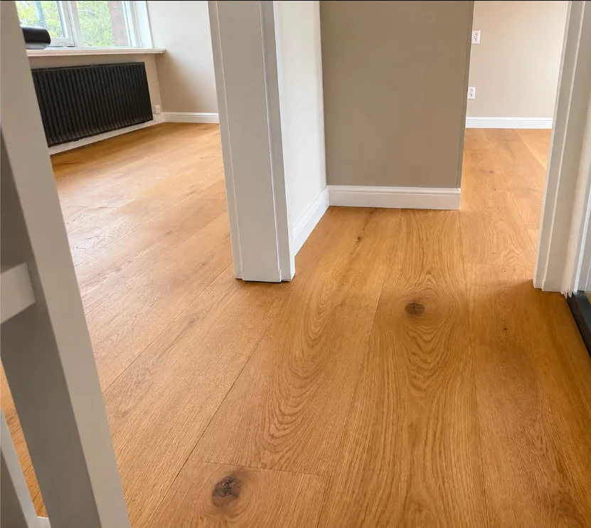 Doorkijk vanuit de hal naar de aangrenzende kamers, waar de eiken parketvloer doorloopt