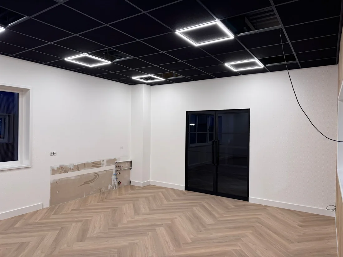 Ruimte met walvisgraatvloer en houten wandpanelen (beeld 5)
